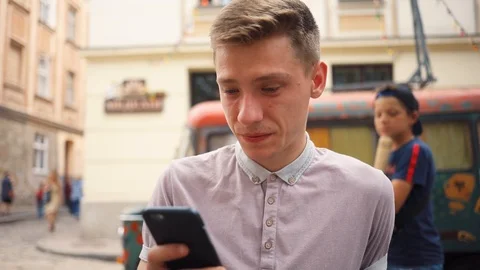 Smiling face handsome young man use phone happy on street mobile love sitting Stock Footage 92419490
