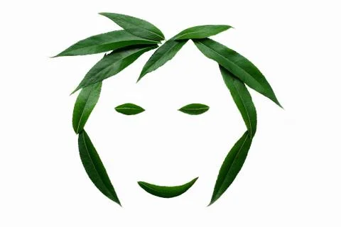 A smiling face, lined with green leaves. The concept of naturalness. Stock Photos