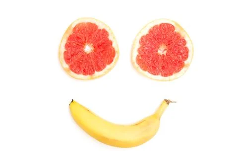 Smiling face made from grapefruit and banana on white background Stock Photos