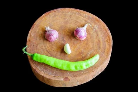 Smiling face made of vegetables and chopping block Stock Photos