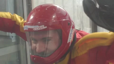 Smiling face of a man in a helmet. freefall training in aero tube 库存影片 91744064