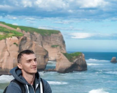 The smiling face of a young man on a background of mountains and sea Stock Photos