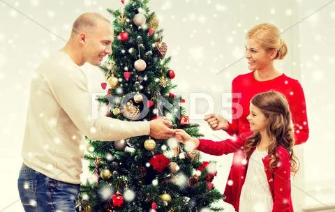 Smiling Family Decorating Christmas Tree At Home