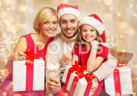 Smiling family holding gift boxes and sparkles Stock Photos