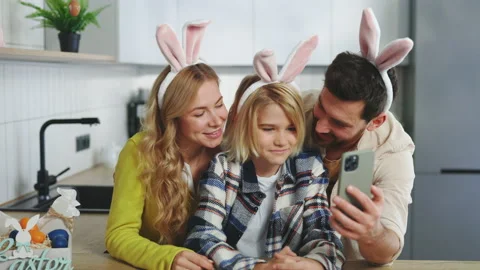 A Smiling Family Is Preparing for the Easter Holiday Using Smartphone to Video Stock Footage 233324632