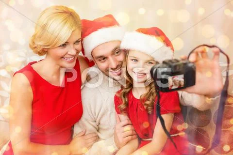 Smiling family in santa helper hats taking picture Stock Photos