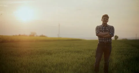 Smiling Farmer Standing In Farm At Sunset. Video stock 246830241