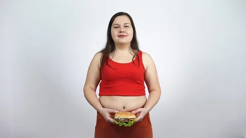 Smiling fat girl eats hamburger,fast food. Gluttony,unhealthy lifestyle. Stock Footage 122744193