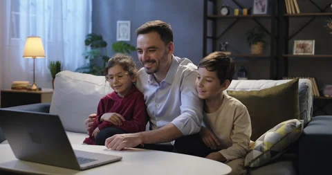 Smiling father and children using laptop talking during online video conference Stock Footage 266736917