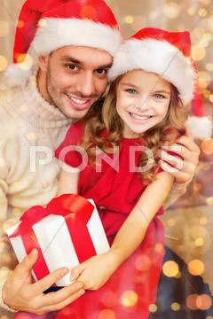 Smiling father and daughter holding gift box Stock Photos
