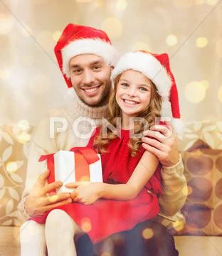 Smiling father and daughter holding gift box Stock Photos
