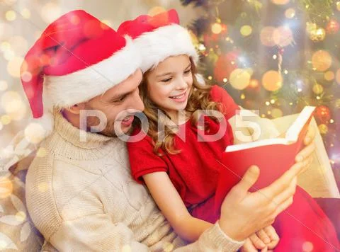 Smiling father and daughter reading book Stock Photos