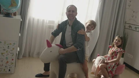 Smiling father having fun with cute children at home Stock Footage 157551935
