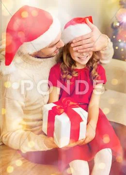 Smiling father surprises daughter with gift box Stock Photos