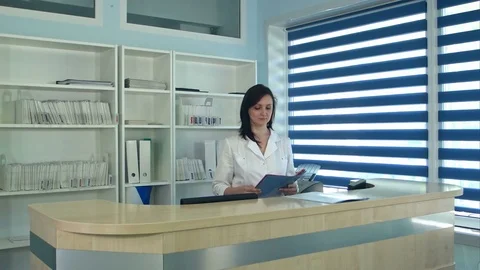 Smiling female doctors standing at the reception desk in hospital Stock Footage 77366635
