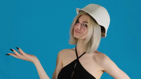 Smiling female engineer in helmet points with hand on blue Video stock 306493987