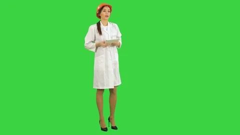 Smiling female engineer with tablet taking to the camera on a Green Screen Vídeos de archivo 71754848