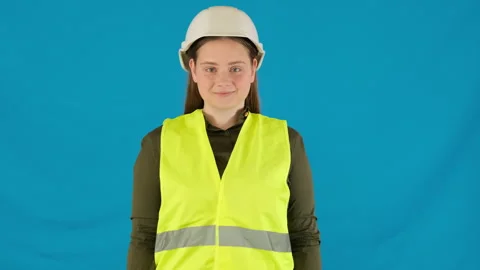 Smiling female engineer in work vest and helmet on blue Stock Footage 316105839