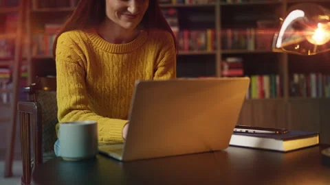 Smiling female freelancer typing on laptop in cozy urban library, working online Stock Footage 340267110