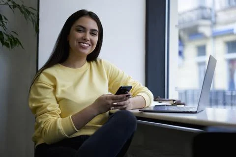 Smiling female freelancer using mobile phone for banking via application and 4G Stock Photos
