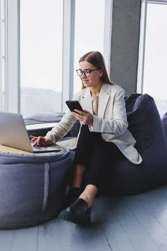 Smiling female manager using mobile phone to check delivery service via onlin Stock Photos