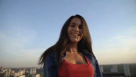 Smiling female model posing at camera on roof top, photo shoot, city view Stock-Footage 117215337