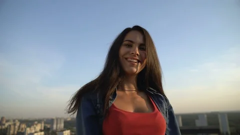 Smiling female model posing at camera on roof top, photo shoot, city view Video stock 117218034