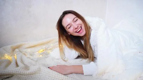 Smiling female posing and gesturing to camera, lying on floor co Stock-Fotos