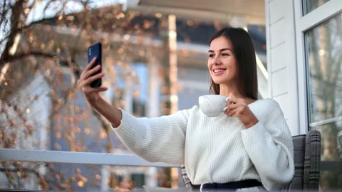 Smiling female posing taking selfie on balcony of countryside house. Medium shot 動画素材 143592583