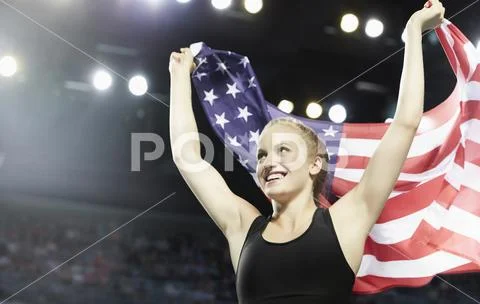 Smiling female runner running victory lap with American flag Stock Photos