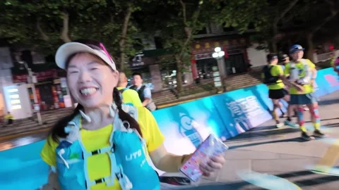 Smiling Female Runner Waving to Camera at Start Corral, Lushan Stock Footage 346701755
