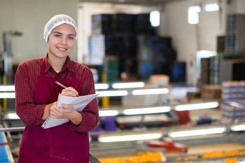 Smiling female shift supervisor with papers at tangerine sorting line Stock Photos