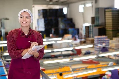 Smiling female shift supervisor with papers at tangerine sorting line Stock Photos