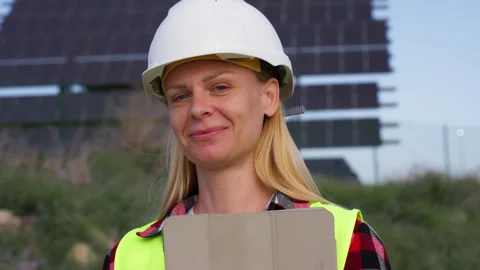 Smiling female solar energy engineer holding tablet in front of photovoltai.. Stock Footage 333581490