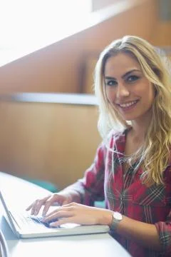 Smiling female student using laptop Stockfoto's