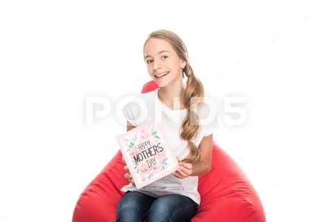 Smiling female teenager holding greeting card for happy mothers day and sitti Stock Photos
