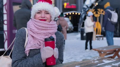 Smiling female in winter clothes with red cup of hot drink outdoor. Stock Footage 202045993