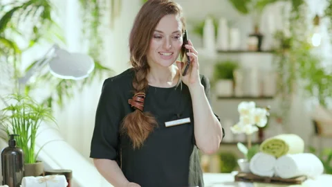 Smiling female worker in beauty studio talking on phone Vídeo Stock 157687499