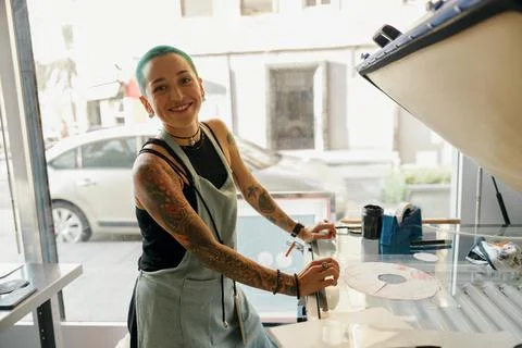 Smiling female worker preparing screen printing film while using printing Stock Photos