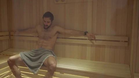 Smiling fit bearded man sweating in the spa sauna Stock Footage 127649023