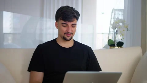 Smiling focused millennial guy typing on computer surfing web looking at screen. Stock Footage 276978615