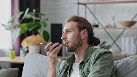 Smiling freelancer using virtual assistant app sets reminder on smart phone at Stock Footage 166322802