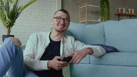 Smiling freelancer is working from home remotely using a mobile and sitting on Stock Footage 156741347