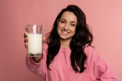 Smiling friendly dark-haired cute young woman showing in front of the camera her Stock Photos