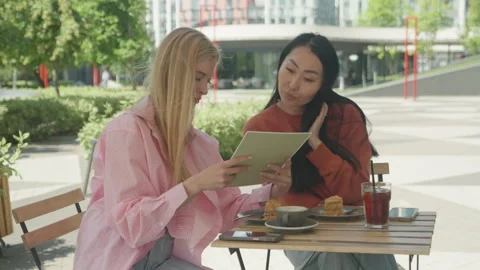 Smiling Friends Browsing Cafe Menu Together On Sunny Outdoor Terrace Stock Footage 313843144