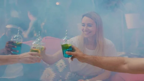 Smiling friends cheering with nice drinks relaxing together in smoky room at Stock Footage 114927748