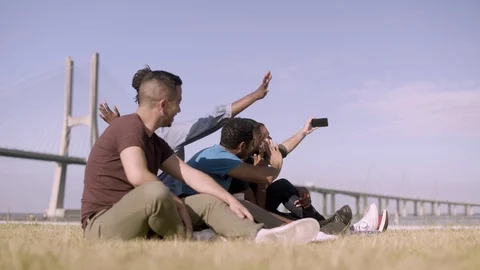 Smiling friends gesturing while taking self portrait with smartphone Vídeos de archivo 113407799