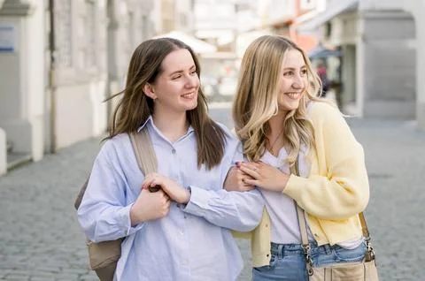 Smiling friends having fun, while walking along the city Stock Photos