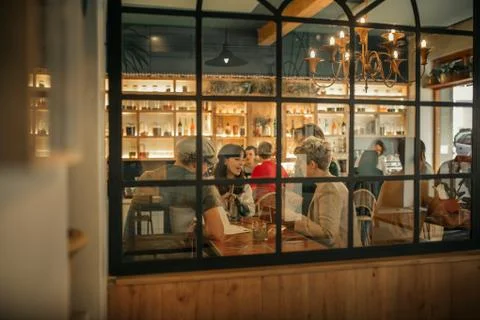Smiling friends ordering drinks inside of a trendy bar Stock Photos