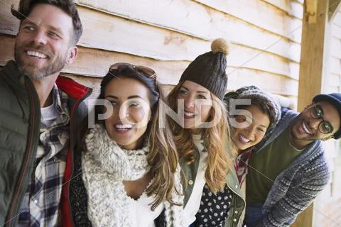 Smiling friends standing in a row outside cabin Stock Photos